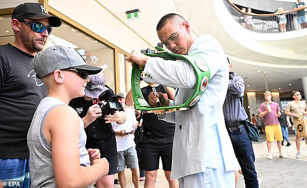 Tim Tszyu signs autographs for young fans using his WBO super lightweight world title belt ahead of his fight against Brian Mendoza