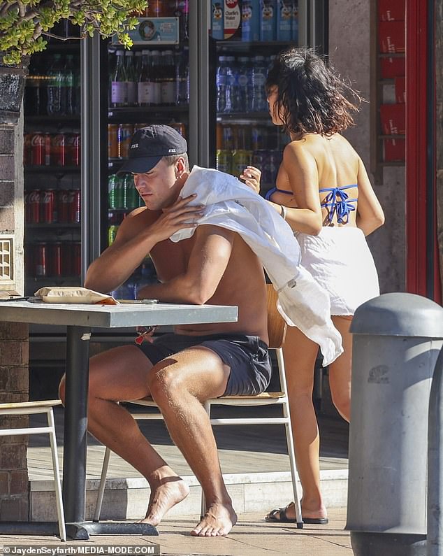 She wore a sky blue bikini as she sat in the sun, while Will was shirtless and wore a pair of black shorts