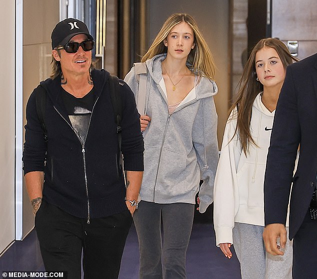 The Australian country music singer, 55, dressed comfortably as he strolled through the arrivals terminal at Sydney International Airport with his children and airport security