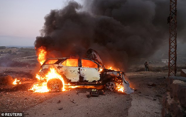 A journalist's car burns at the site where Mr Abdallah was killed in an airstrike