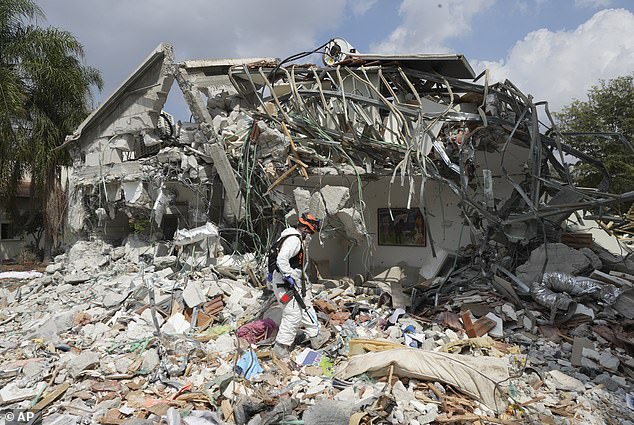 As devastating attacks by Hamas continue, an Israeli soldier walks past a house destroyed by Hamas in Kibbutz Be'eri on Wednesday, October 11, 2023