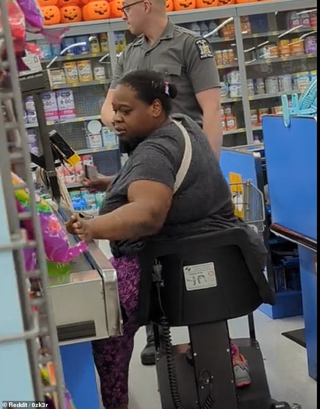 A plus size black woman in a gray tee shirt and bright purple leggings is seen riding a motorized scooter as a white male cop with glasses approaches her online