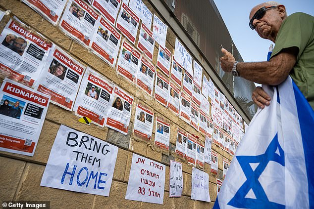 Demonstrators put up placards with the names and faces of those allegedly kidnapped by Hamas outside the Israel Defense Forces headquarters in the Kirya, Tel Aviv.