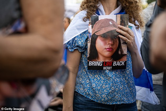 A woman holds a placard calling for the return of Liri Elbag, believed to have been taken hostage by Hamas, during Saturday's protest