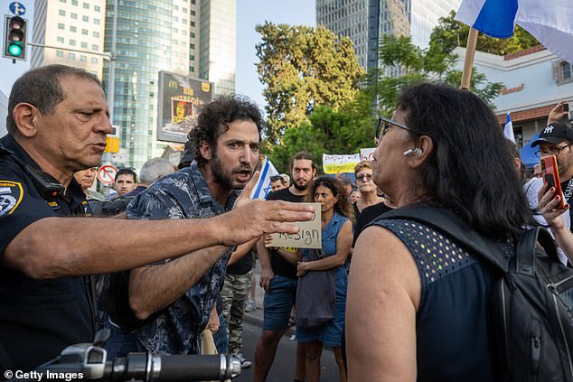 Protesters are separated by an Israeli police officer, after allegedly having an argument over the release of hostages from Hamas, during a demonstration on Saturday