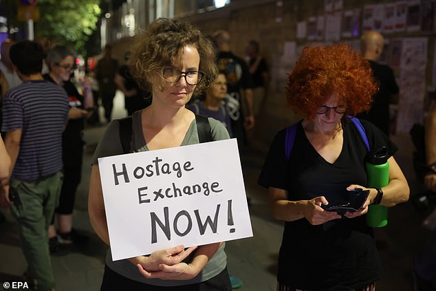 A woman holds a sign calling for the Israeli government to negotiate a hostage exchange with Hamas - the government says it will not make any deals with the terror group