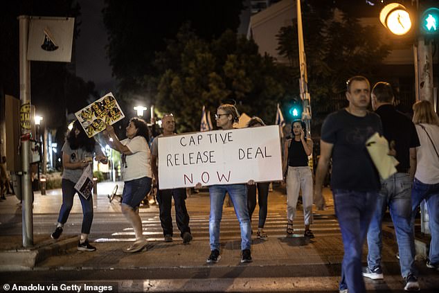 An Israeli protester holds a sign calling for the government to negotiate a release deal for Hamas hostages in Tel Aviv on Saturday.