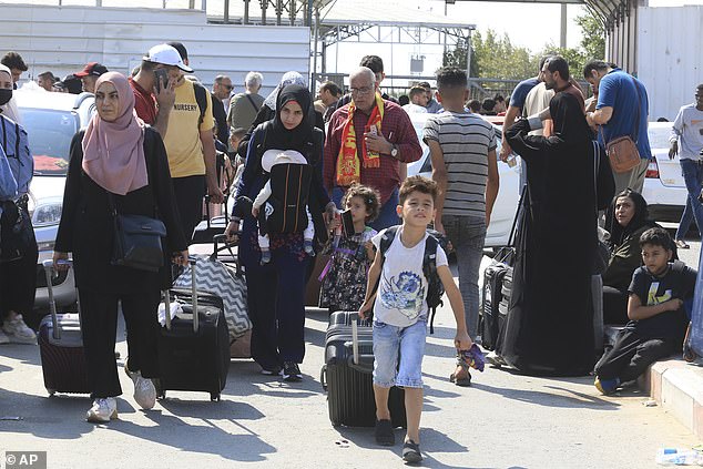 Palestinians are pictured on Saturday waiting at the border with Egypt and trying to get out of the enclave