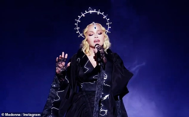 Perfection: Madge wore a long dramatic black gown with billowing sleeves and a silver halo-style crown to ensure she could be seen by every single member of the sold-out crowd