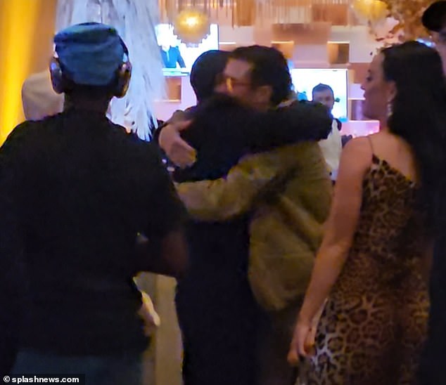 Enter that: The boys hugged as Katie looked on