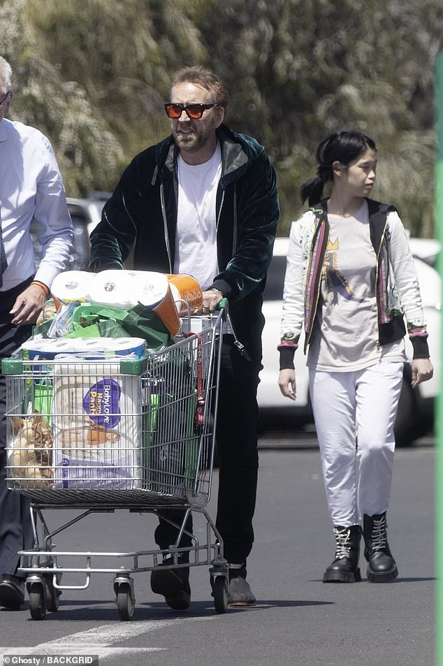 Nicholas wore his signature Elvis-style sunglasses, a velvet hoodie, jeans and cowboy boots as he visited an Asian grocer, picking up fresh fruit and vegetables from the store before visiting a local supermarket