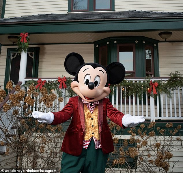 A Mickey Mouse character posed outside Disney's childhood home