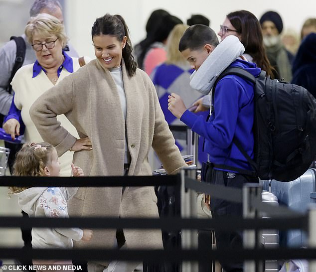 Luxury getaway: The mother-of-five was instead pictured smiling with her son Taylor, 13, and daughter Olivia, three, as the family queued to check in their luggage