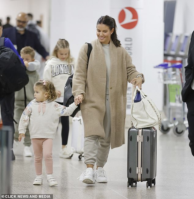 The Dancing On Ice star was in full parent mode as she held daughter Olivia's hand while pushing her suitcase and white designer bag through the terminal with the other