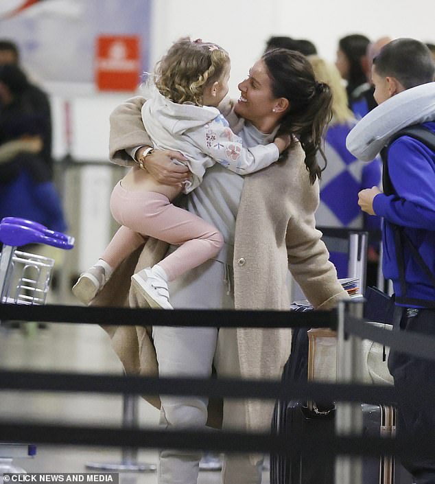 Cute: Rebecca beamed at little Olivia as she and four of the five children made their way through the airport