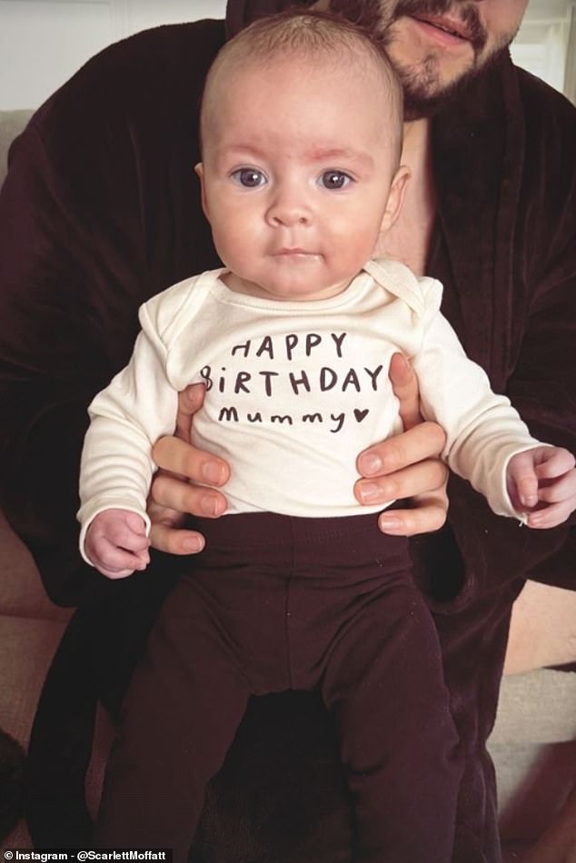 Adorable: Little Jude was pictured being held by dad Scott while wearing a long-sleeved white shirt designed with a personalized message that read: 'Happy Birthday Mum.'