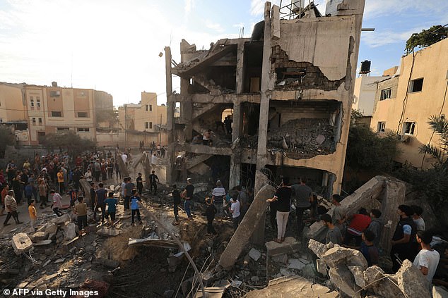 Palestinians search the rubble of a building after an Israeli attack in Khan Yunis in the southern Gaza Strip on October 17, 2023