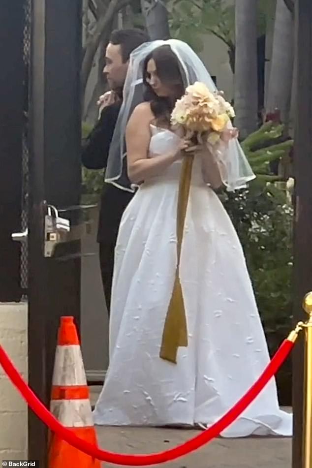 The bride, wearing a strapless white dress and veil, stood back to back with her new husband in the iconic Charlie's Angels pose