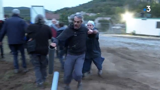 The nun clutches his coat and pulls the eco-protester to the ground in what almost looks like a professional rugby tackle