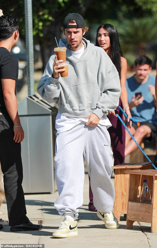 Casual attire: For his coffee run, the Peaches hitmaker pulled on an oversized gray hoodie over an oversized white T-shirt.  He wore very baggy pants, as well as egg yellow and black Nike sneakers