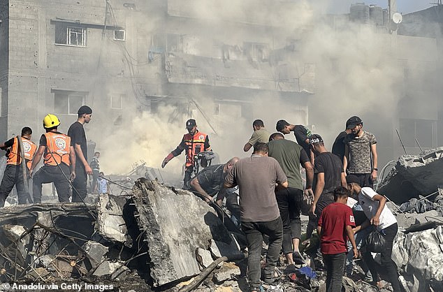 Teams carry out search and rescue operations after Israeli airstrikes on a building in the Al Bureij refugee camp in Deir al-Balah on Tuesday