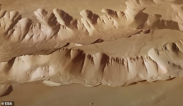 Busy: Mars Express has taken thousands of photos since arriving at the fourth planet from the Sun in December 2003, including capturing the tattered landscape of the canyons that lie between Mars' Valles Marineris and the massive volcanoes of the Tharsis Bulge (pictured)