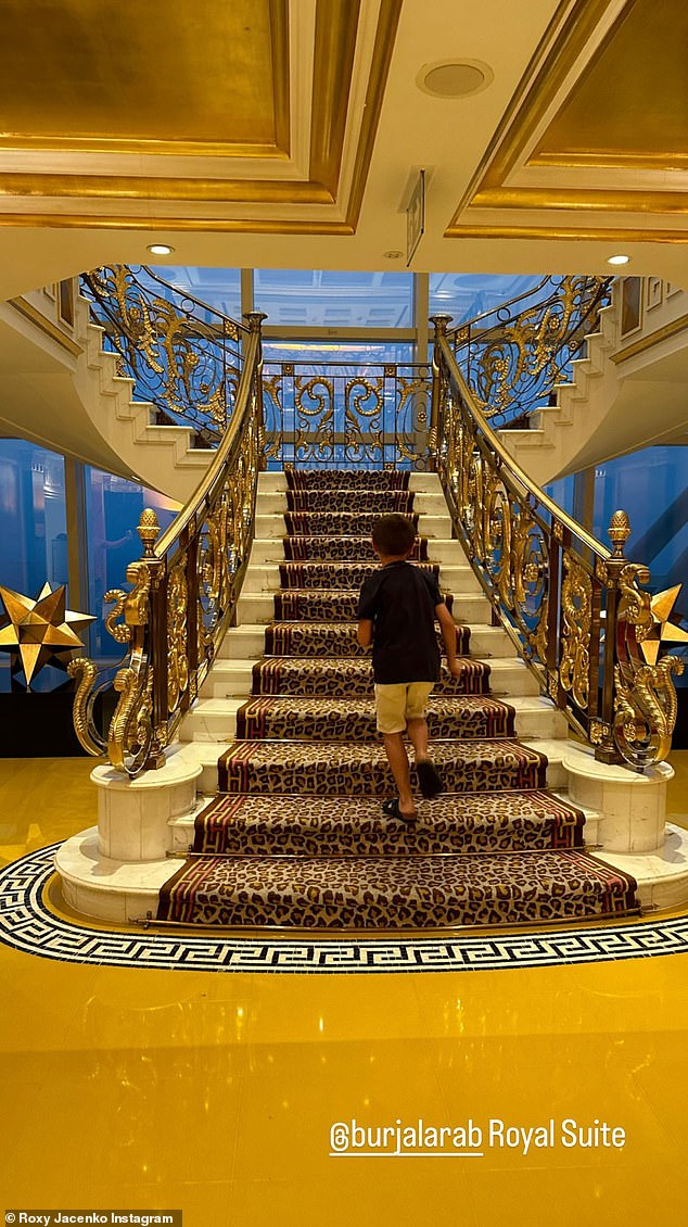 The PR expert, 43, is staying in the 'Royal suite' of the luxury seven-star Burj Al Arab hotel in the Middle East.  In a photo she took of the suite, her son Hunter, nine, is seen walking up the room's elaborate 22-carat gold and marble staircase.