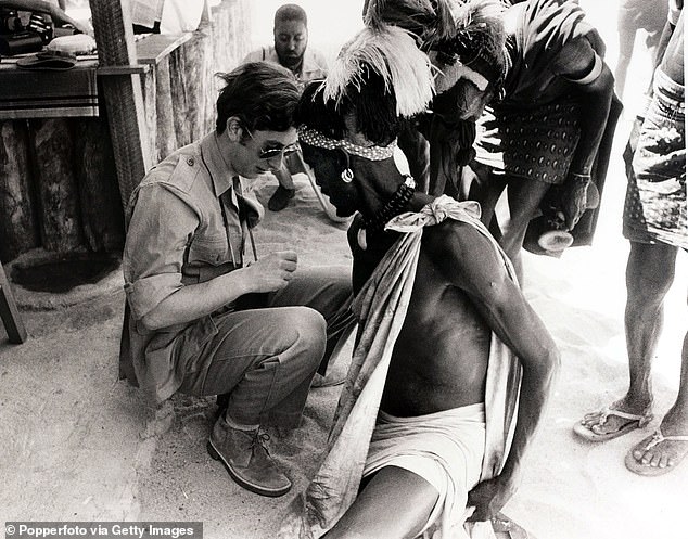 Twenty-two-year-old Prince Charles sits on a Turkana stool during a visit to Kenya's Great Rift Valley and Lake Rudolf - now Lake Turkana - in 1971