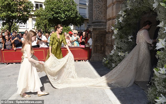 Princess Victoria's bridesmaids wear her long lace train as she enters the Iglesia de San Miguel