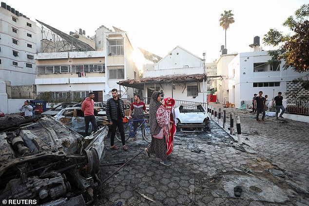 People inspect the area of ​​Al-Ahli Hospital where hundreds of Palestinians were killed in an explosion that Israeli and Palestinian officials blamed on each other on Wednesday