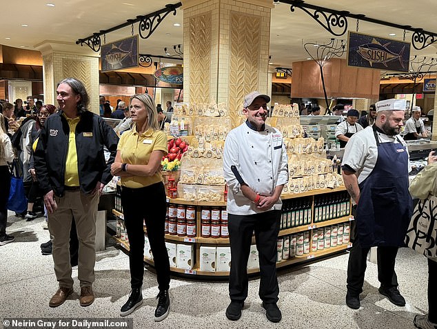 Pictured are a handful of the store's 600 employees greeting customers as they enter the new store for the sushi concession on Wednesday morning