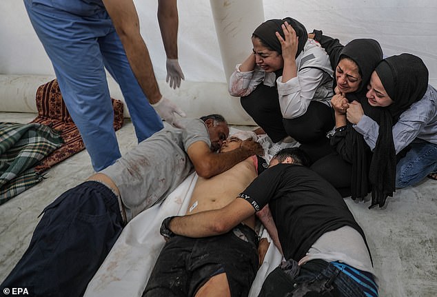 Palestinians in Al Shifa Hospital mourn the body of a relative after the explosion at al-Ahli Hospital on Tuesday