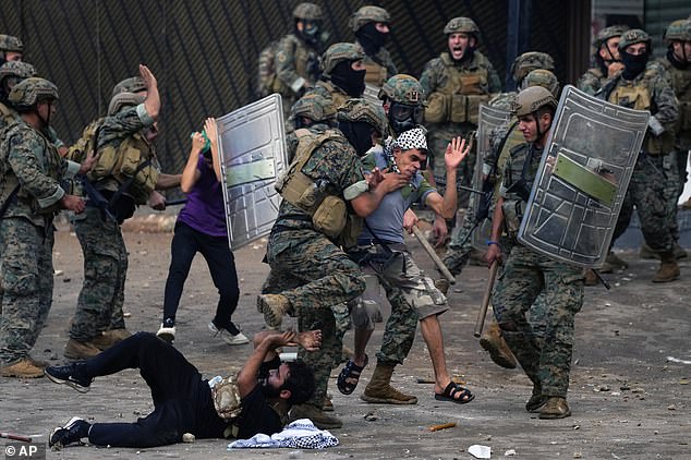 Lebanese army soldiers fight with protesters during a demonstration in solidarity with the Palestinian people in Gaza, near the US embassy