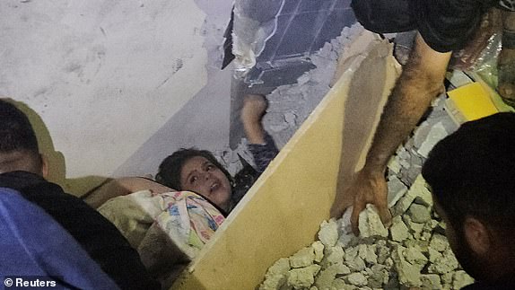 Palestinians try to rescue a boy trapped in rubble after an Israeli attack on a house in Jabalia in the northern Gaza Strip, October 19, 2023. REUTERS/Anas al-Shareef