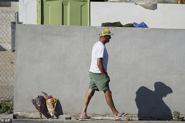 A man walks past the makeshift shrine set up for the victims of the horrific crash