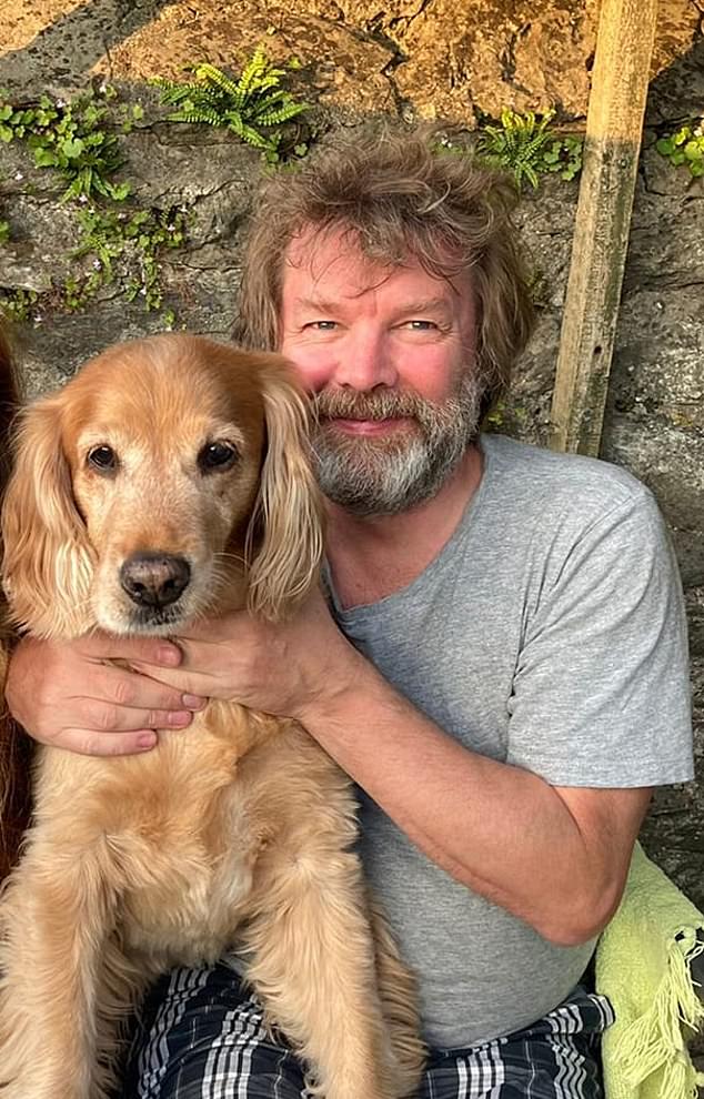 Jonathan, a math and computer teacher, is seen here smiling and happy in a photo with his golden retriever Ralph