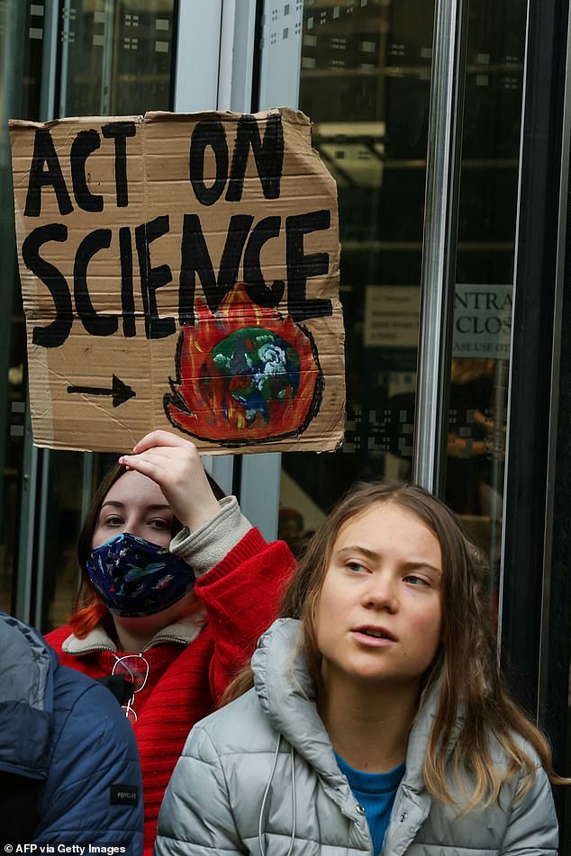 Climate activists, including Swedish climate activist Greta Thunberg, hold banners and chant slogans on October 19