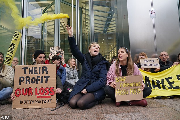 Banners read 'their profit, our loss' and 'stop financing fossil fuels'