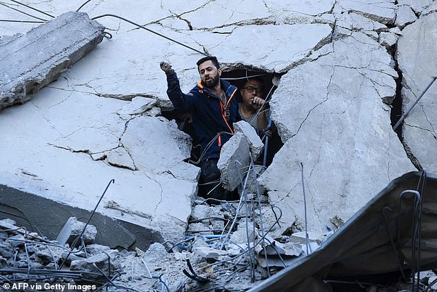 Members of the Palestinian Civil Defense search for survivors Thursday in the rubble of a building hit during the Israeli bombardment of Khan Yunis in the southern Gaza Strip