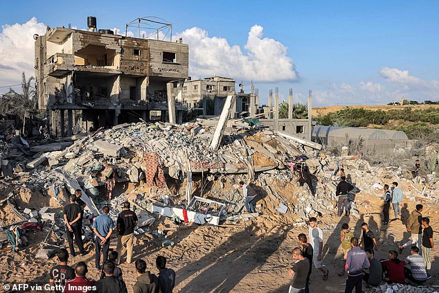 People gather Thursday near the rubble of a destroyed building after the Israeli bombardment of Rafah in the southern Gaza Strip