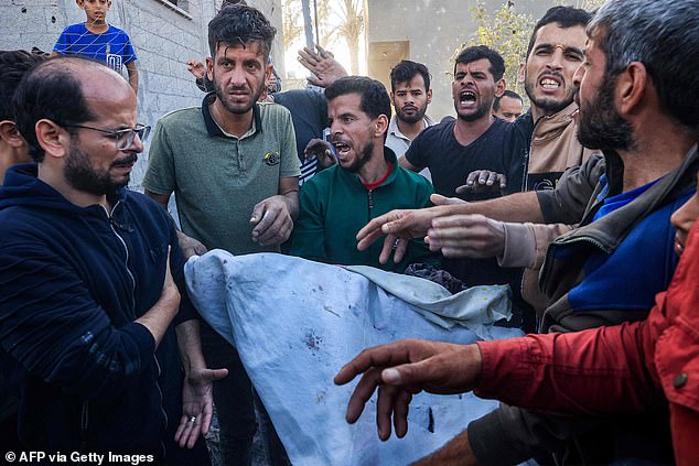 A man carries away the body of a person killed in an Israeli bombing after being rescued from the rubble of a building in Rafah, southern Gaza Strip, on Thursday.