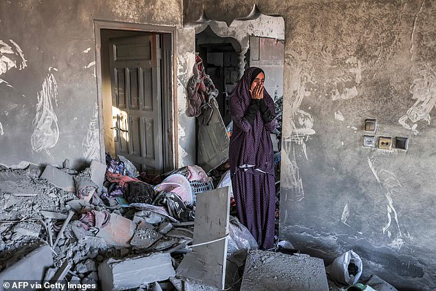 A woman cries as she stands in a badly damaged house after the Israeli bombing of Rafah on Thursday