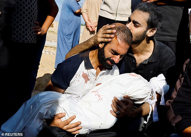 The father of Alma Al Majayda, three, holds her body after she was killed in Israeli attacks.