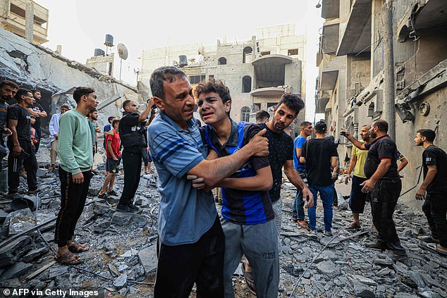 People cry as Palestinian Civil Defense members and others search for survivors in Khan Yunis