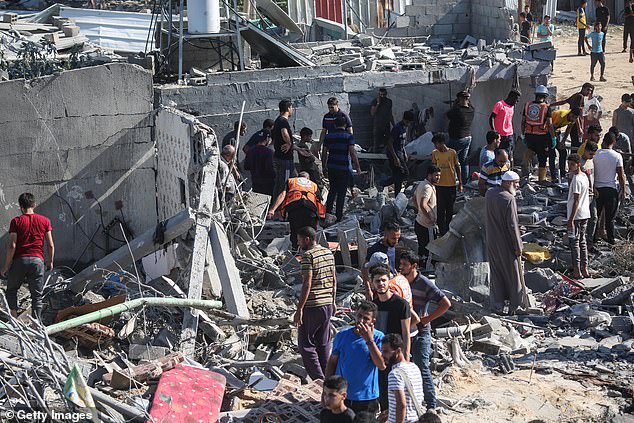 Palestinian emergency services and local civilians search for victims in buildings destroyed during Israeli airstrikes in the southern Gaza Strip