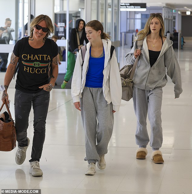 Meanwhile, daughters Sunday, 15 (pictured left) and Faith, 12 (pictured centre), were twinned in gray tracksuits as they walked with their dad through the terminal