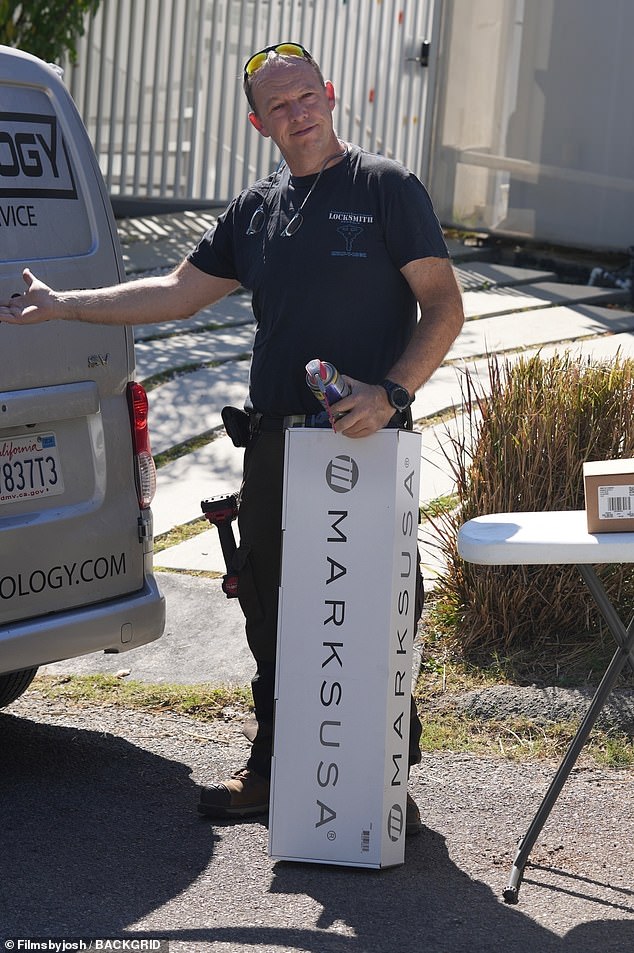 A locksmith is seen at the Brentwood home on Thursday, although it is unclear why they were called