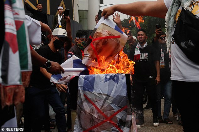 MALAYSIA: Malaysians burn the photos of Israeli President Isaac Herzog and the country's flags as they protest outside the US Embassy in support of Palestinians in Gaza in Kuala Lumpur on Friday