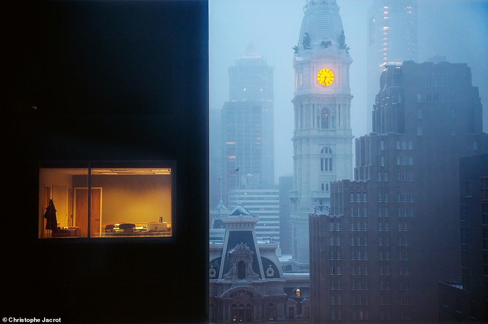 In this stunning shot, the light from the City Hall clock tower brings a warm glow to the misty streets of Philadelphia, Pennsylvania