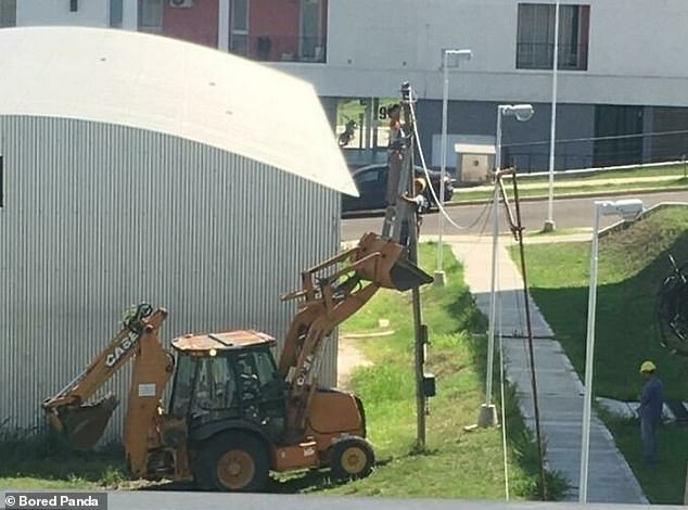 This image, taken in the US, is a bit unclear, but it appears to show two guys standing at the top of a telecom pole.  They appear to have reached it by climbing a ladder placed in the elevated scoop of an excavator